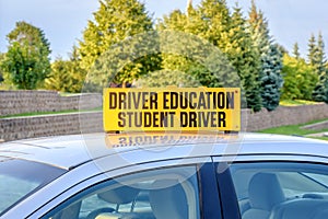 Yellow student driver sign on roof of car