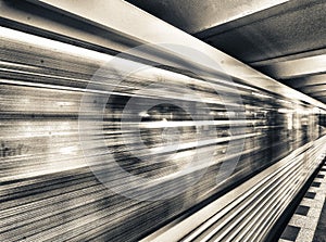 Yellow subway train speeding up on a city station. Business and