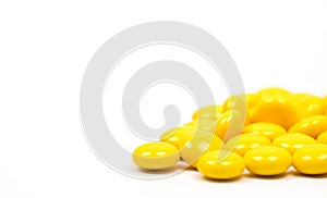 Yellow sugar coated tablets pills on white background