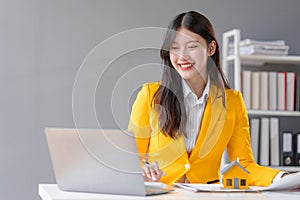 Yellow suit female asian people real estate agents and loan providers at work. Business professionals sketching futures,