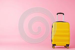 a yellow suitcase is sitting on a pink background