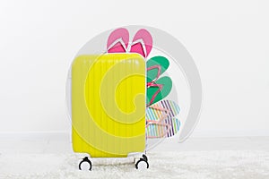 Yellow suitcase on white background Summer holidays. summer flip flops or slippers.Sandals beach.Travel valise or bag. Mo