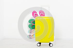 Yellow suitcase on white background Summer holidays. summer flip flops or slippers.Sandals beach.Travel valise or bag. Mo