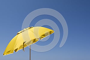 Yellow sun umbrella isolated on blue sky
