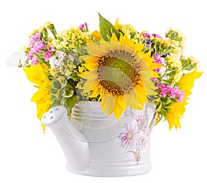 Yellow sunflowers and colored wild flowers in a white sprinkler, close up