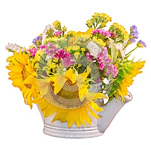 Yellow sunflowers and colored wild flowers in a white sprinkler, close up