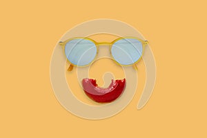 Yellow sunglasses and half bite red donut sets as smile mouth