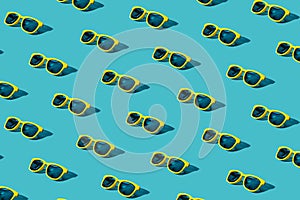 Yellow sunglasses pattern on turquoise blue background