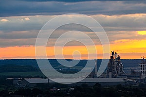 Yellow sunset over industrial landscape with factory chimneys and pipes with smoke polluting the atmosphere