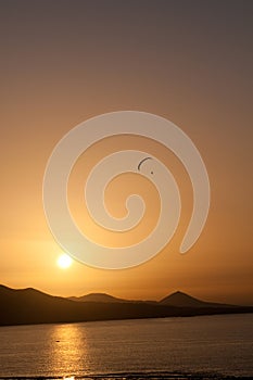 Yellow sunset with paragliding in a beach