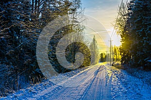 Yellow sunset on a snowy countryside road