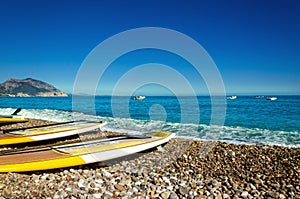 Yellow surfboards on pebble beach, Golfo di Orosei, Sardinia, Italy