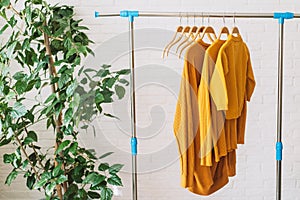 Yellow sweatshirts on wooden hangers hang on an iron bar rale photo