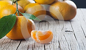 Yellow sweet isolated peeled and whole mandarin clementine tangerine on wooden rustic vintage table with leaf. Tangerines backgrou