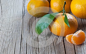 Yellow sweet isolated peeled and whole mandarin clementine tangerine on wooden rustic vintage table with leaf. Tangerines backgrou