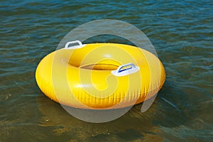 Yellow swim ring floating on a sea