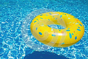 Yellow Swimming Pool Ring Float in Vibrant Blue Water\