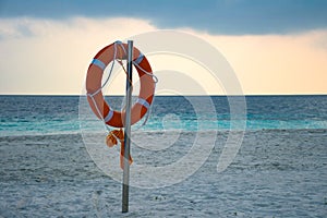 Yellow swimming rescue ring mounted on the pole