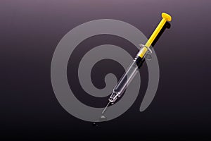 Yellow Syringe on black background