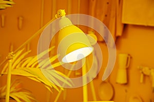 Yellow table lamp on an orange background. An abstract composition in warm colors and an idea for decorating a room. Foreground.