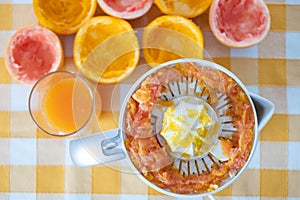 Yellow table with squeezer for a mix of fruit juice for healthy breakfast or break. Freshness and vitamines from citrus, orange photo