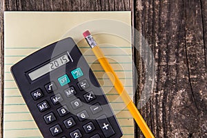 Yellow Tablet Pencil & Calculator on Vintage Desk