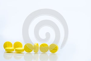 Yellow tablets pills on white background with space