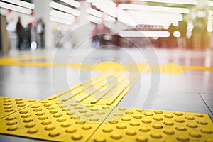 Yellow tactile pavement for the blind on the floor in the mall