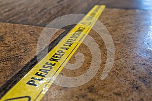 Yellow tape on the floor of a pub to ensure that customers maintain social distancing