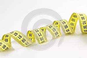Yellow tape measure in meters and inches in a spiral
