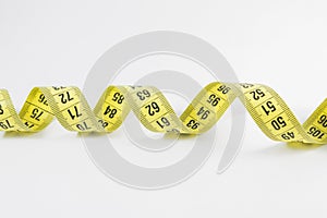 Yellow tape measure in meters and inches in a spiral