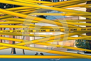 Yellow Tape With Stay Home Warning Sign At Street. Quarantine. Social Distancing. Self Isolation. Lockdown. 3d rendering photo