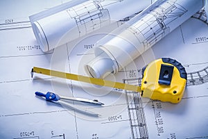 Yellow tapeline compass and rolls of blueprints
