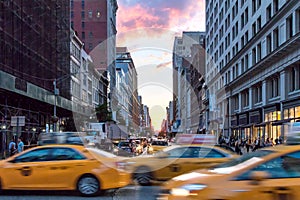 Yellow taxi cabs speeding down Broadway during rush hour in New York City photo