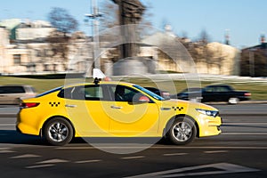 Yellow taxi car in motion on city street