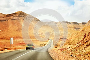 The yellow taxi rides along the mountain road in the Mid Atlas Mountains.