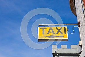 Yellow Taxi Sign against the blue sky