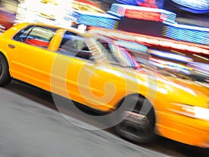 Yellow taxi speeding near Times Square in New York.