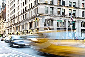 Yellow taxis and cars driving down the congested streets of Midtown Manhattan in New York City with motion blur