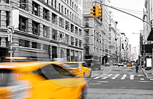 Yellow taxis driving in black and white street scene on Fifth Avenue in Manhattan New York City