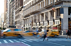 Yellow taxis in motion on 5th Avenue through Midtown Manhattan New York City