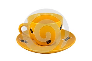 A yellow tea mug with a handle on a yellow saucer. Isolated item on a white background