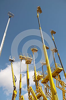 Yellow telescopic cranes under a blue sky