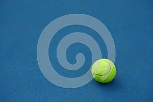 Yellow tennis ball on blue carpet. photo