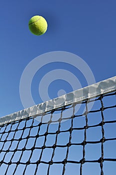 Yellow Tennis Ball Flying Over the Net