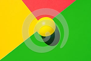 Yellow tennis ball on green red triangle intersection. Abstract colorful graphic geometric background. Business innovation