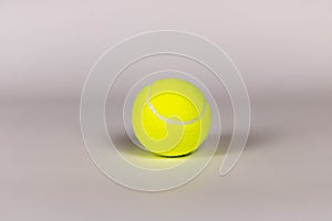 Yellow tennis ball on a light background. Close-up