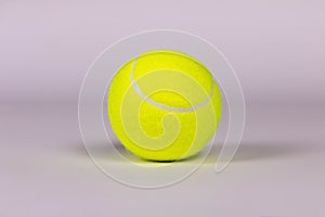 Yellow tennis ball on a light background. Close-up