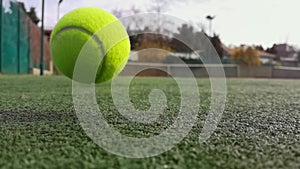 Yellow tennis balls in super slow motion 1000 fps on a clay green court next to the white line with copy space, soft