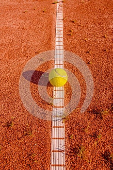 Yellow tennisball on a old court photo